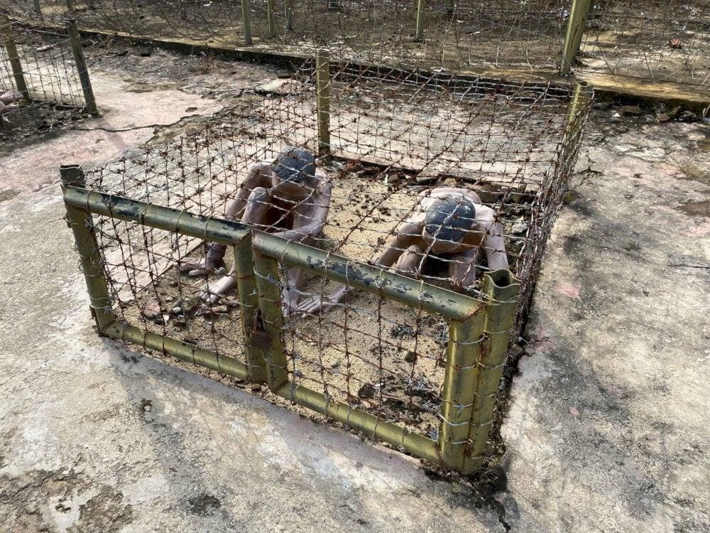 Inside the tiger cages, prisoners were forced to crouch or kneel to prevent injury from the sharp metal surrounding (AI gen lại)